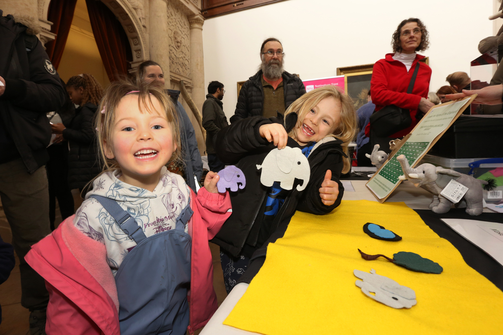 2 girls holding up elephants