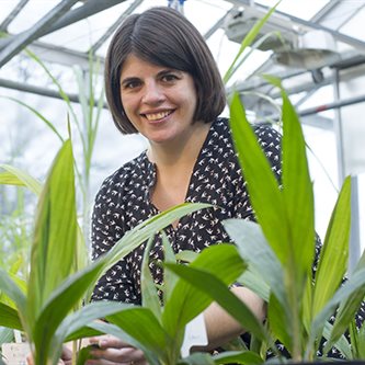 photo of a white woman smiling in a greenhouse