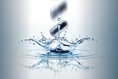 A pill dropping into water, causing a splash