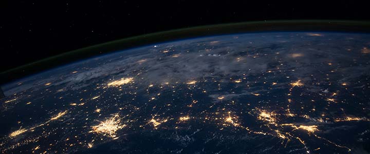 A satellite view of the Earth from space with lots of city lights shining