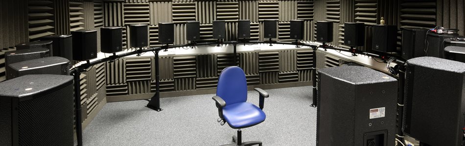 An empty office chair in the middle of a ring of speakers