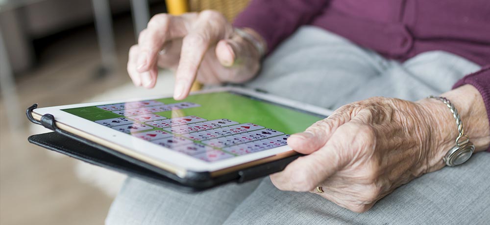 Close up of elderly person's hands using an iPad