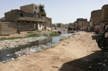Photograph of a river polluted with plastic and rubbish in its banks