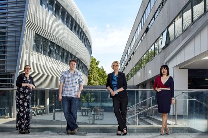 Four academics standing in a courtyard