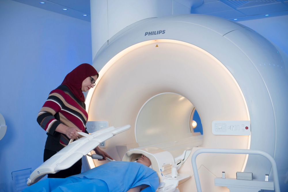Researcher helping patient in the MRI scanner