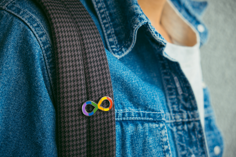 Young boy with autism infinity rainbow symbol sign. World autism awareness day, autism rights movement, neurodiversity, autistic acceptance movement