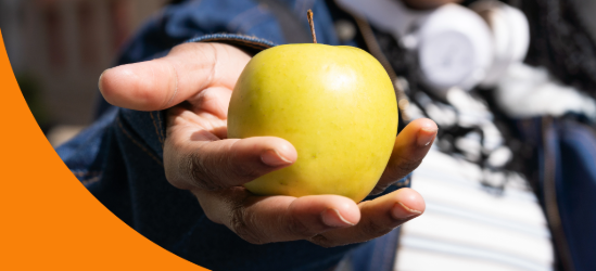 Young student offering a golden delicious apple. Healthy food concept