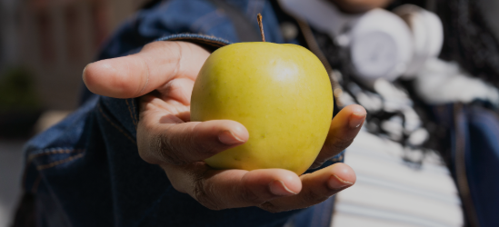 Hand holding apple up close