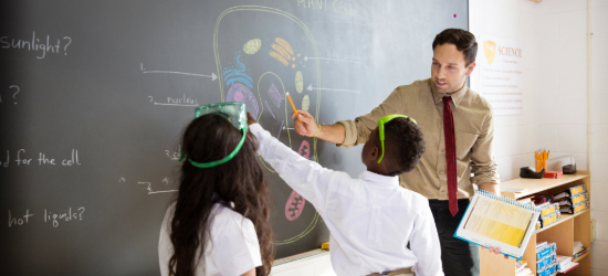Teacher and students learning at the blackboard