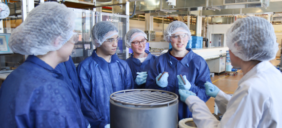 Studenys wearing blue PPE in a food lab
