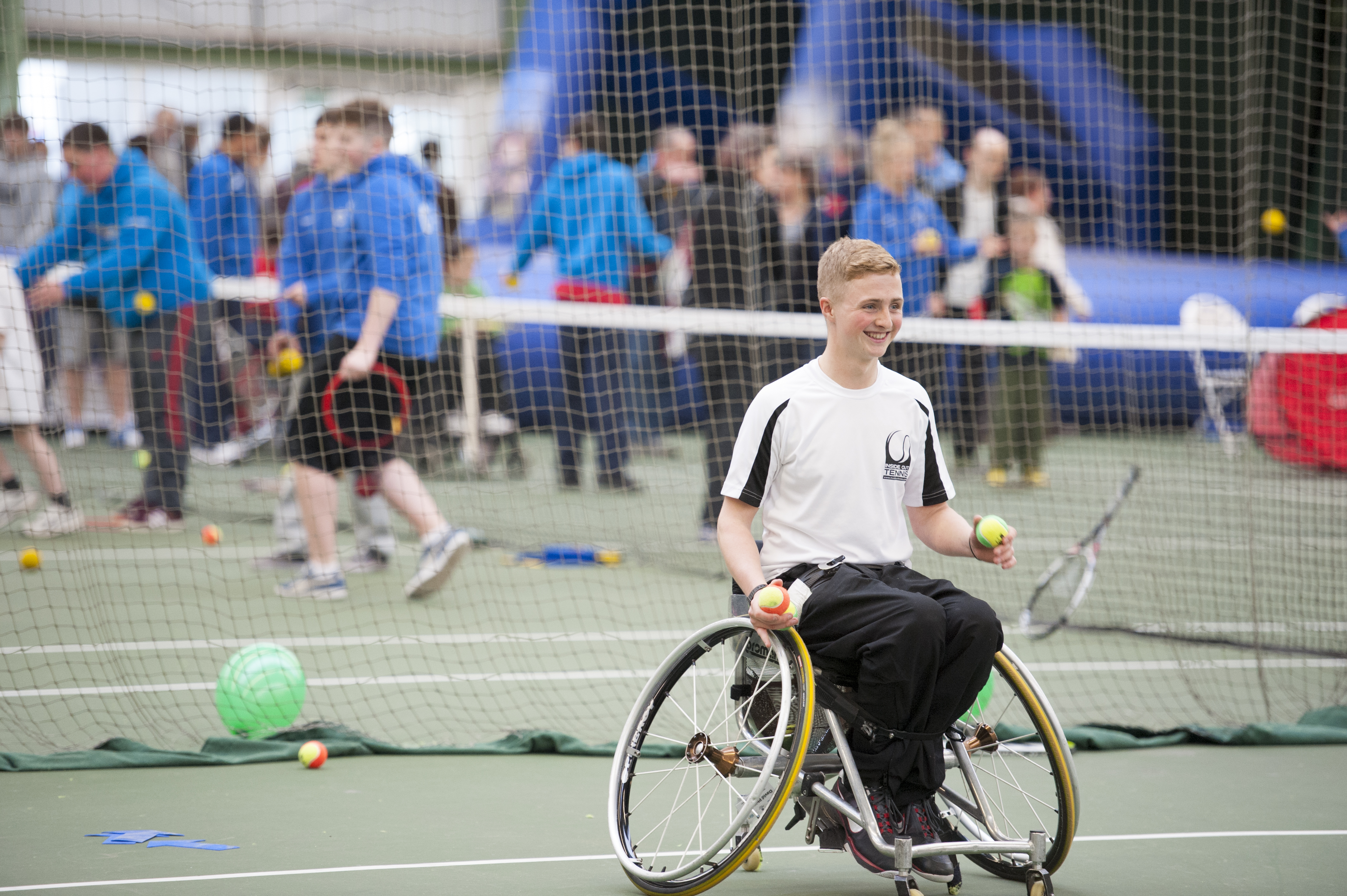 A photo of a student playing wheelchair tennis.