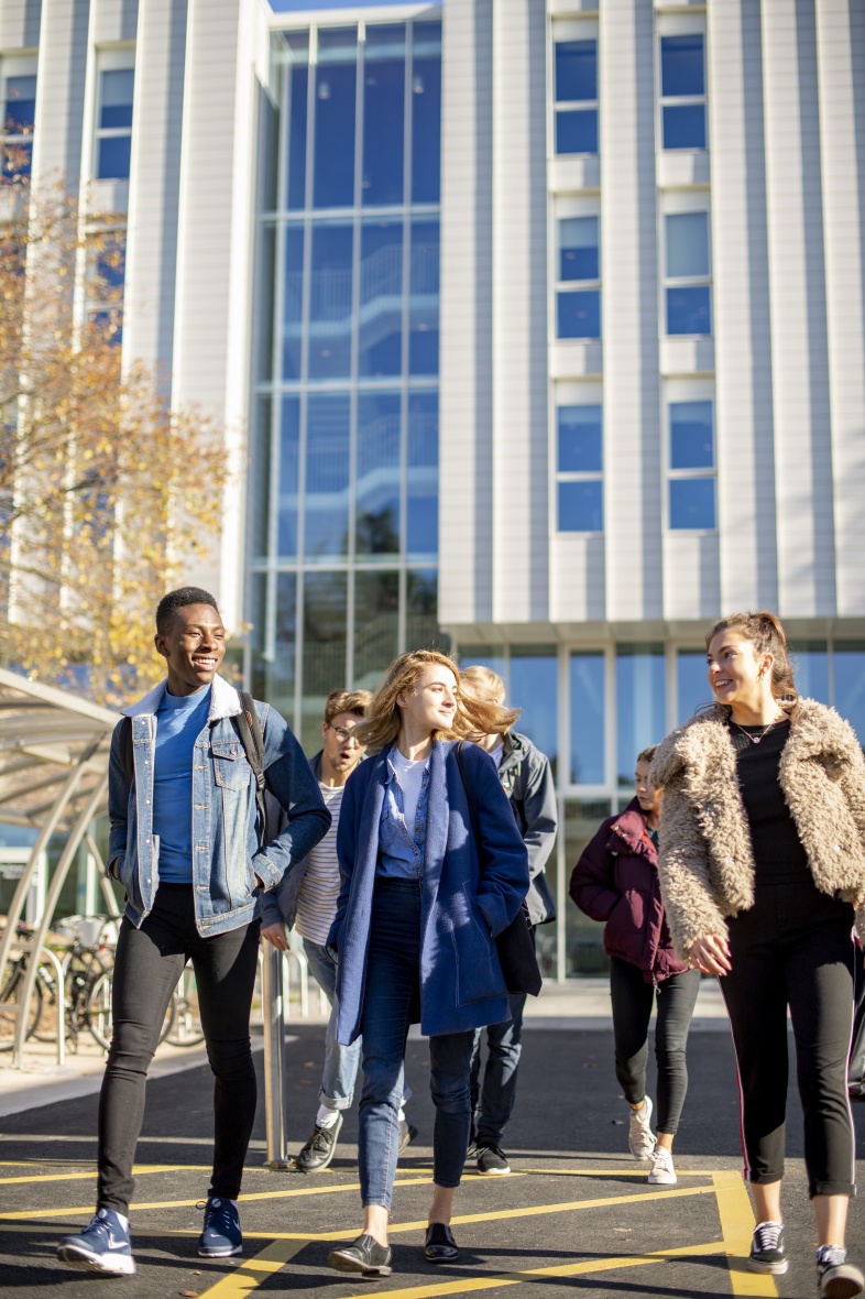 Undergraduate students walking past the Monica Partridge Building, University Park