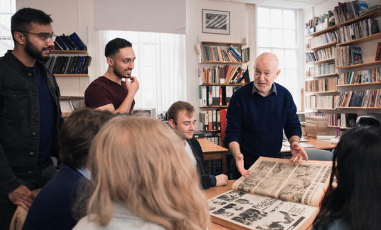 Students and a lecturer looking through archives