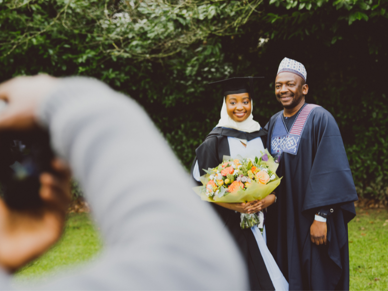 Photograph of a graduate taking a photo with their family