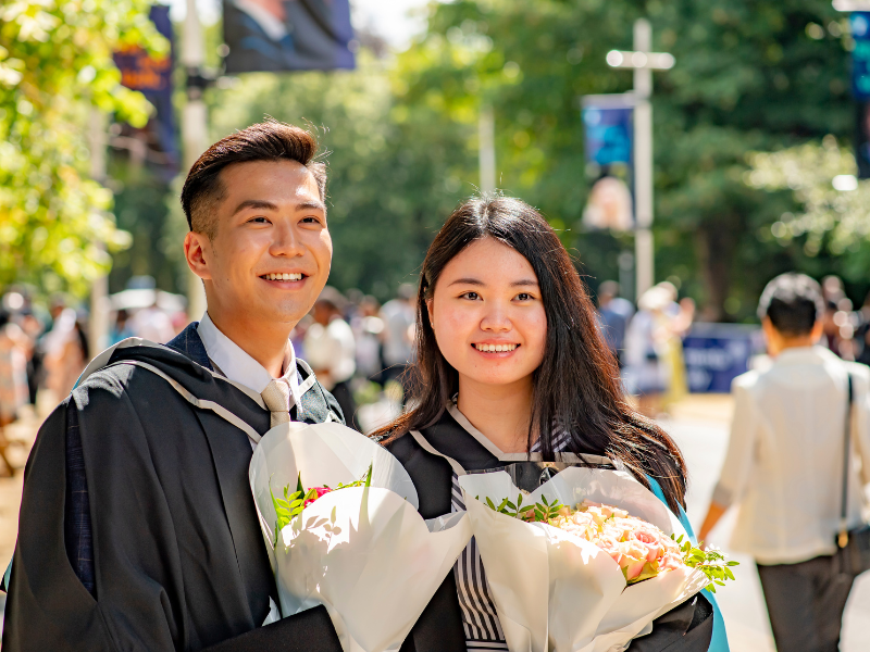 Photograph of two graduates smiling at the camera