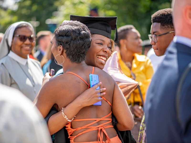 Photograph of a graduate hugging a family member