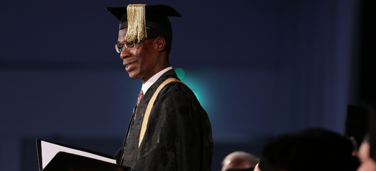 Photograph of a person wearing a gap and gown during a graduation ceremony