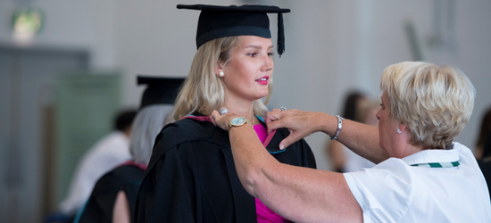 Graduating student having their gown fitted