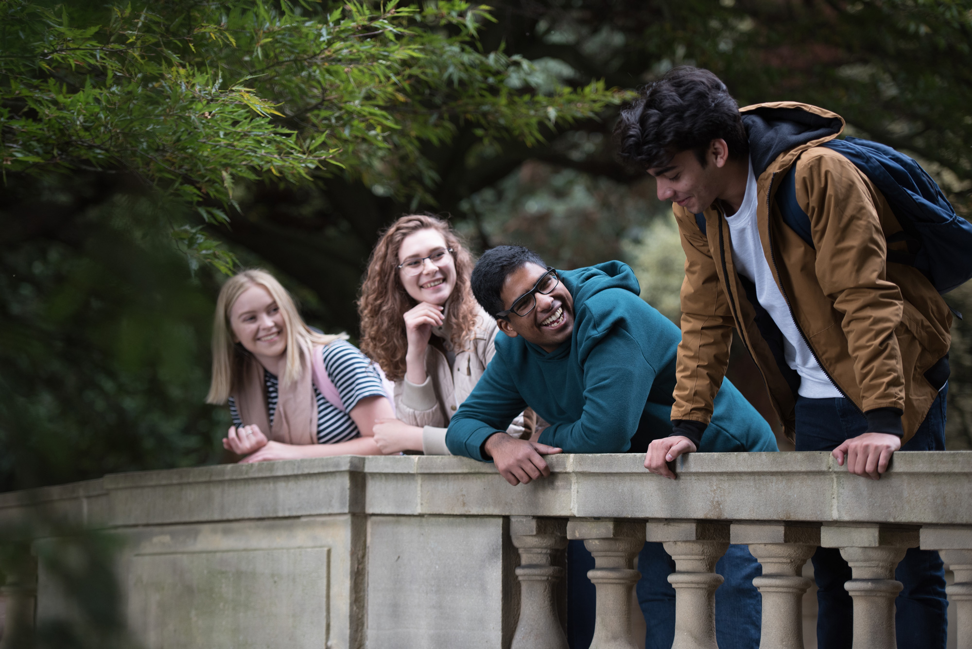 Four students chatting on a bridge