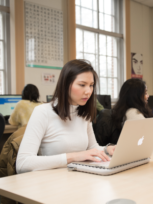 Student working on laptop in language lab